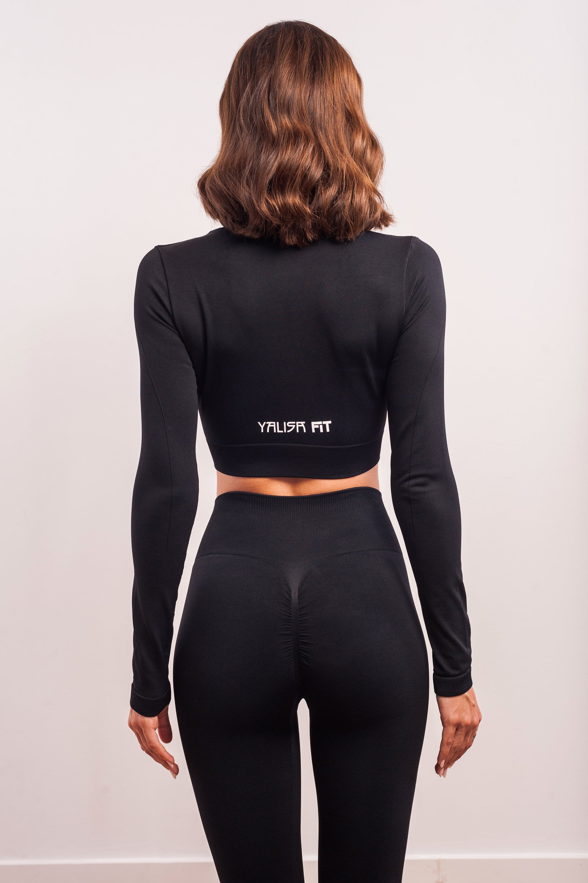 Mujer de espaldas con un conjunto deportivo de leggins de color negro